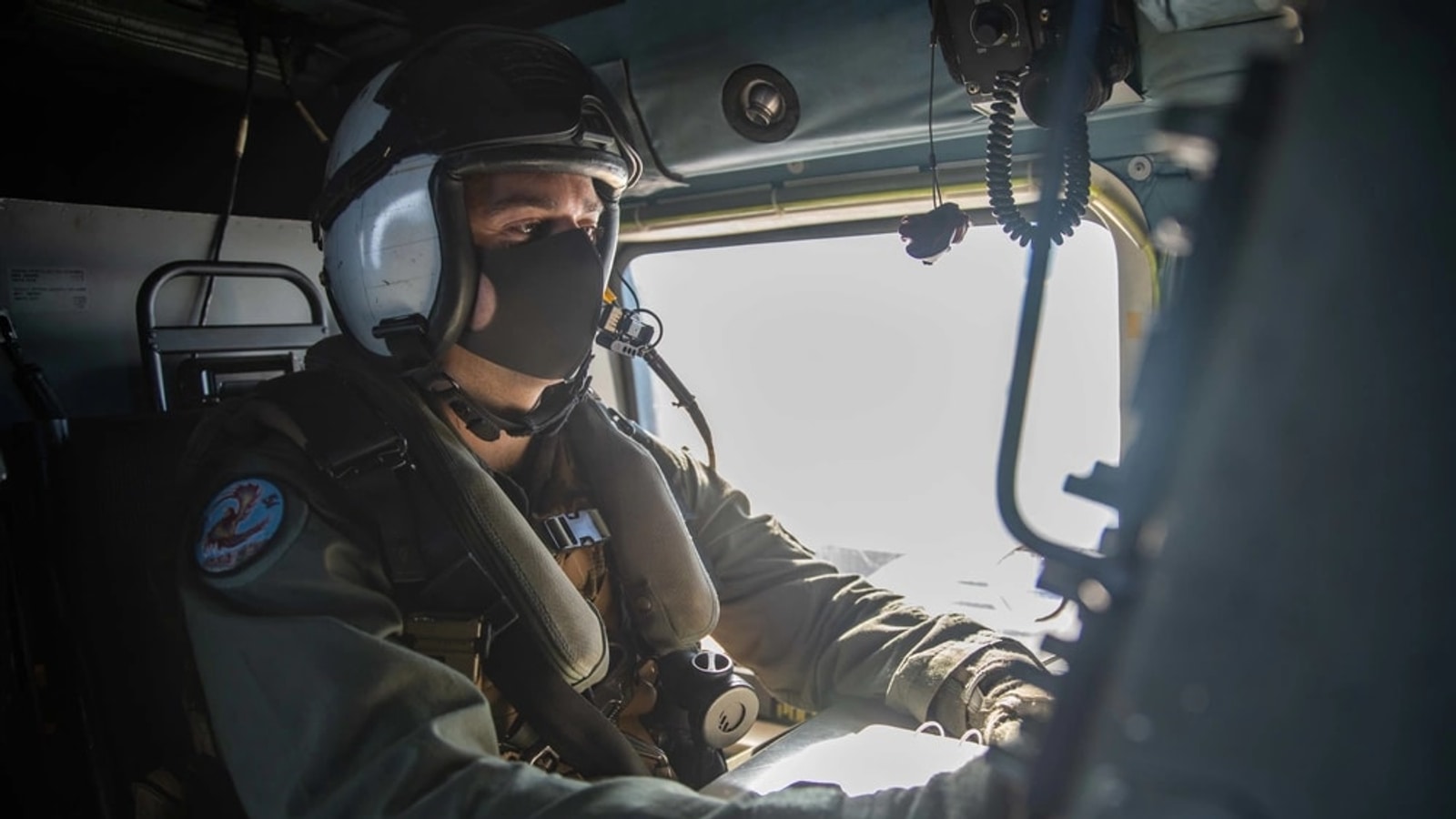 Naval air crewman operating a radar console aboard an MH-60R helicopter