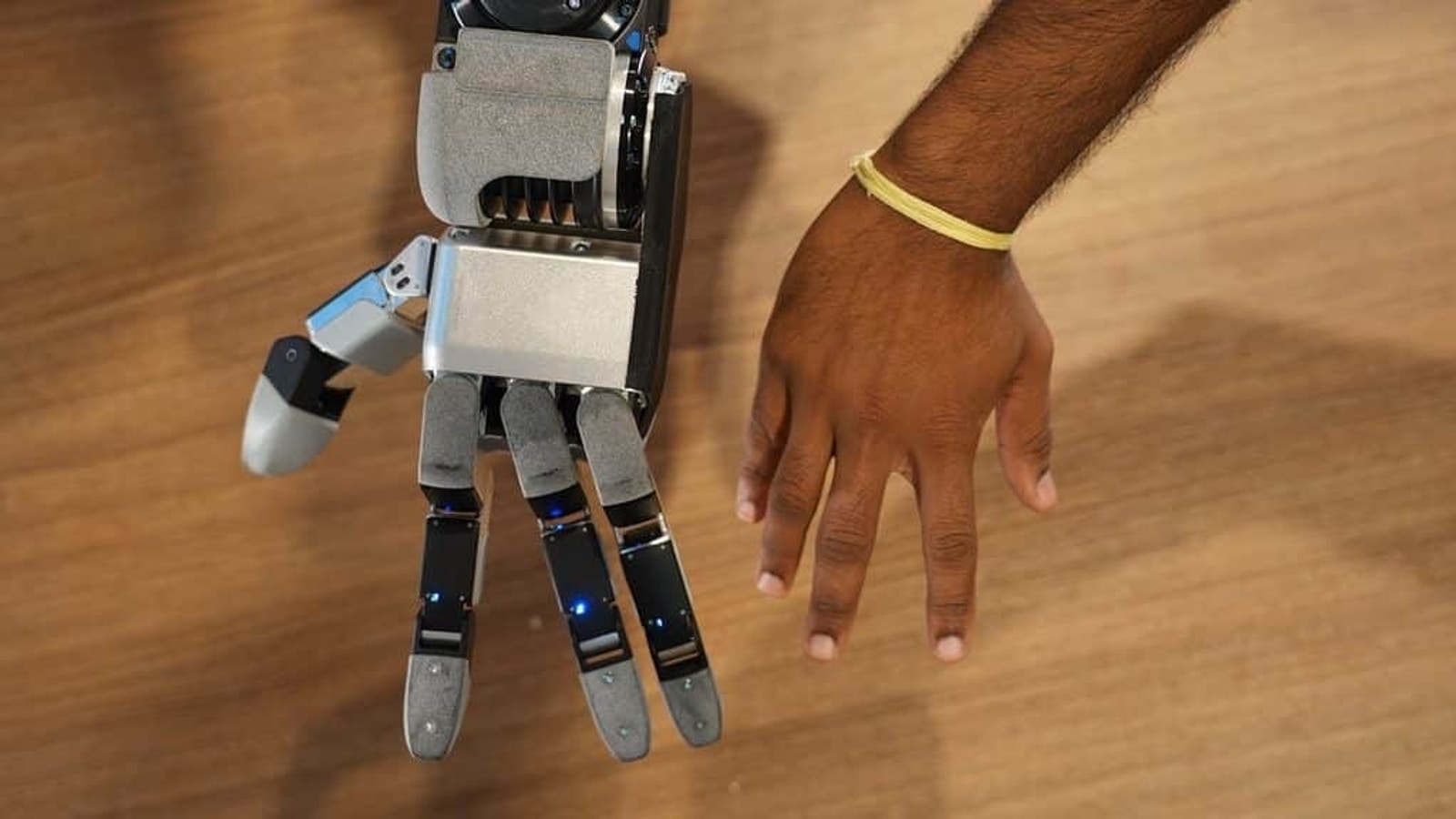 Boston Dynamics Atlas three-finger robotic hand beside a human hand
