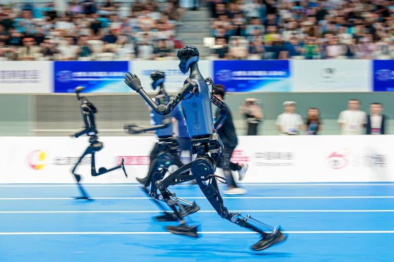 Humanoid robots running on a track in promotional coverage for the World Humanoid Robot Games