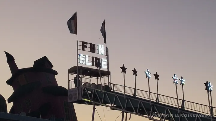 The Fun Slide sign rises above the midway.