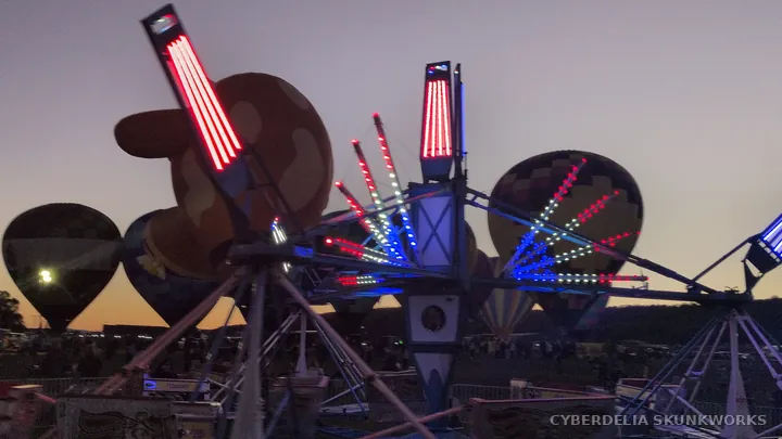Red light bars mark the arms of a carnival ride.