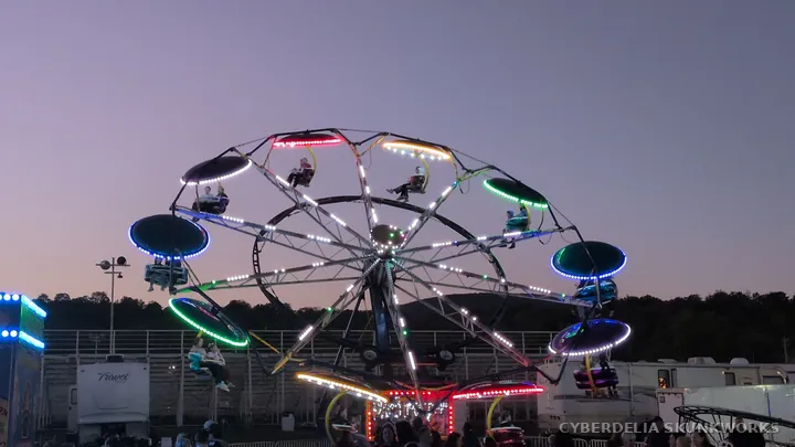 A circular carnival ride forms a ring of lights against the sky.
