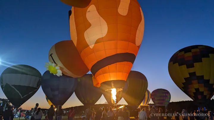 A burner illuminates the cow-shaped balloon from below.