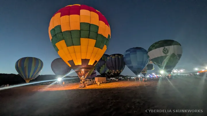 A yellow-and-checkered balloon glows among the assembled aircraft.