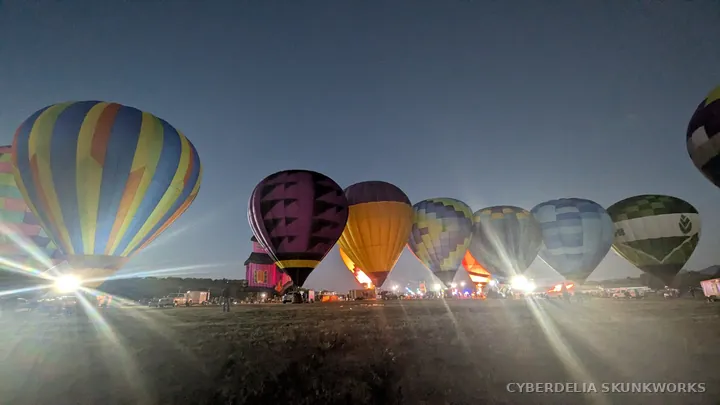 A line of colorful balloons fills the nighttime field.