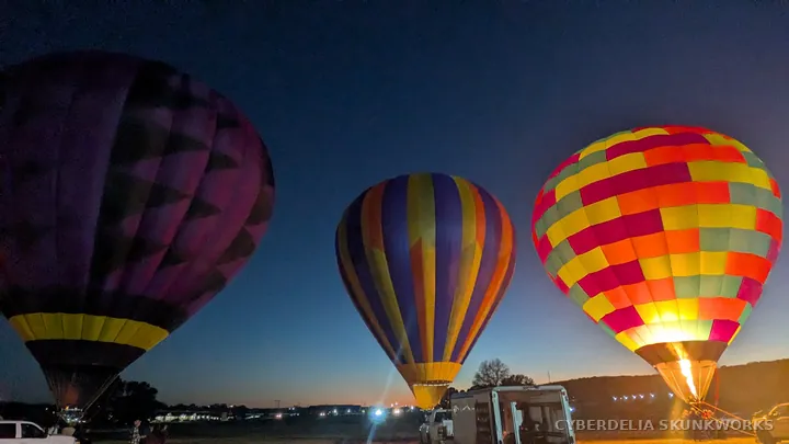 A glowing checkerboard balloon stands beside a darker striped envelope.