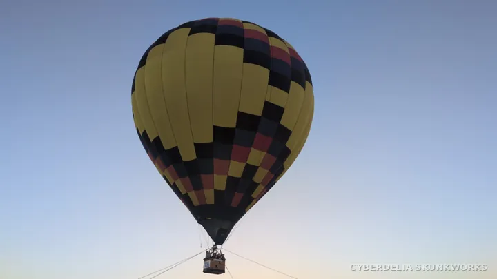 A yellow balloon stands above its tether lines.