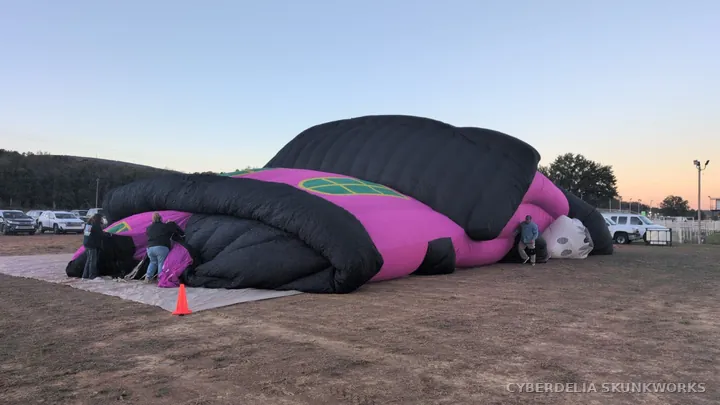 A pink-and-black special-shape envelope lies partly inflated.